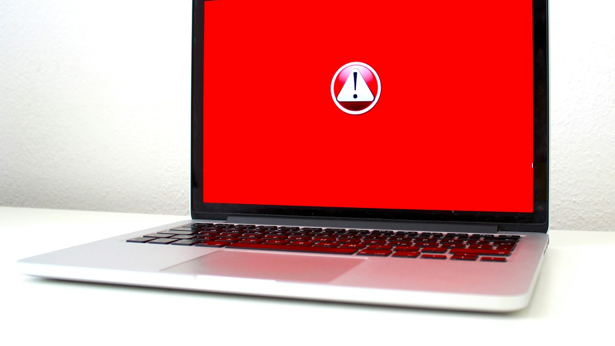 A laptop screen displaying a red system warning alert