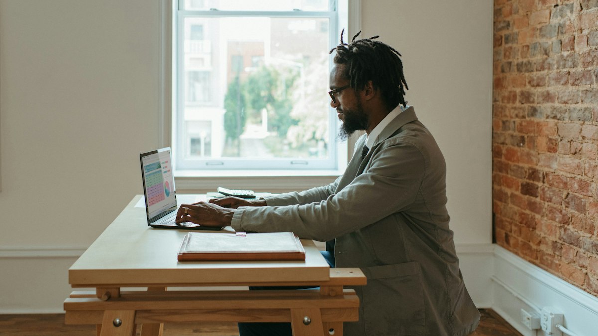 A property manager reviewing a rental application on a laptop at a desk