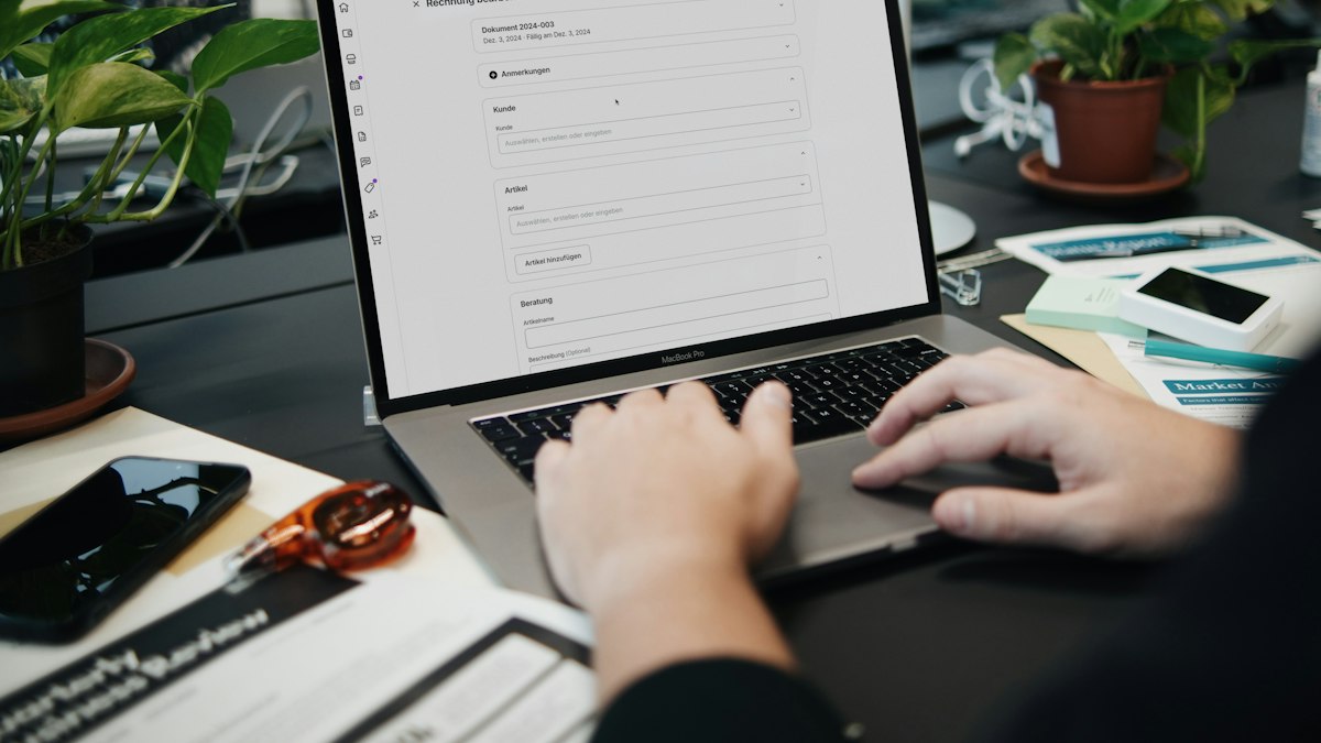 A person reviewing a document on a laptop at a desk