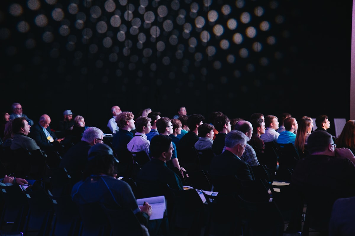 Live concert crowd with colorful stage lighting and a packed venue, representing event marketing and social media promotion for Kansas City events