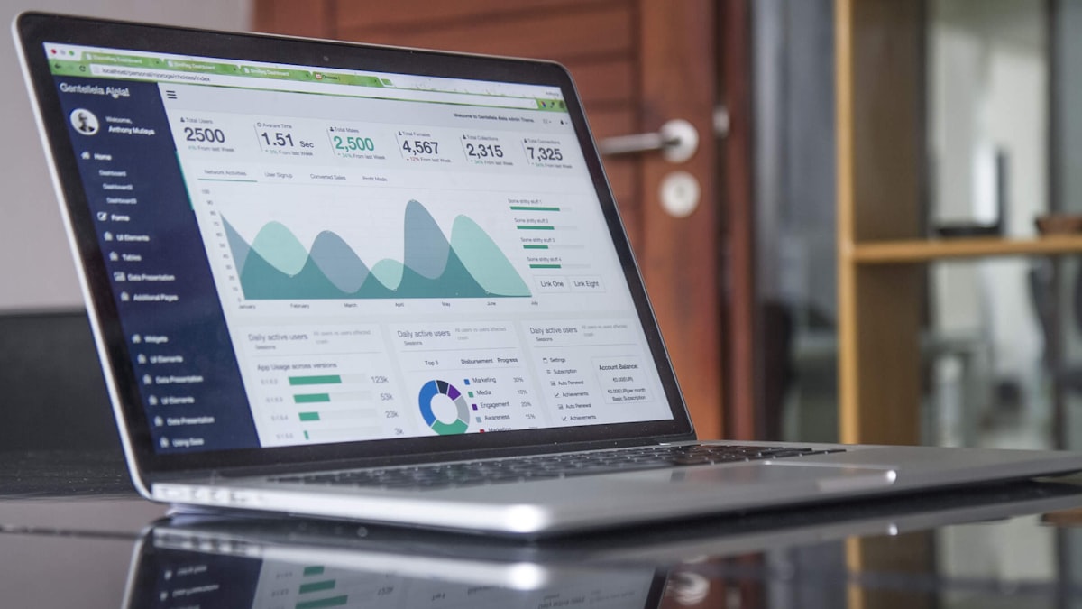 Laptop on a desk displaying financial performance graphs and analytics charts