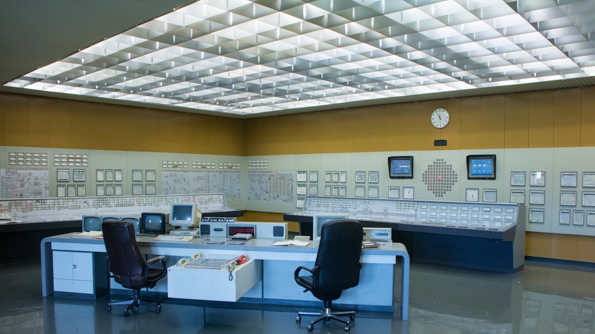 A control room style workspace with multiple monitors displaying different data dashboards side by side