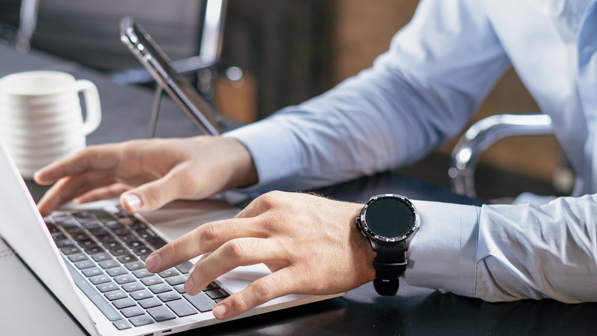 A person typing on a laptop at a desk, reviewing options before making a decision